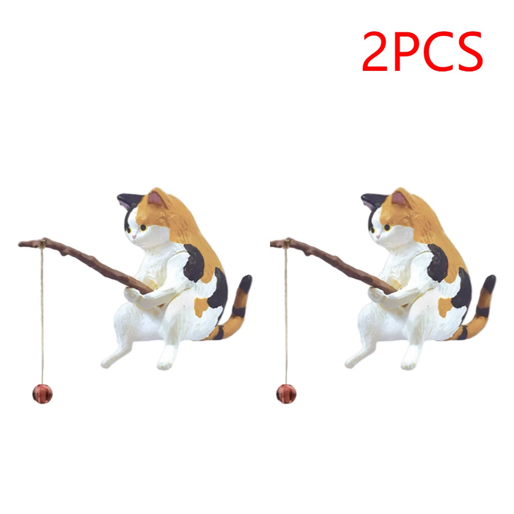 Two cute calico cat aquarium ornaments, each holding a small wooden fishing rod with a hanging ball.