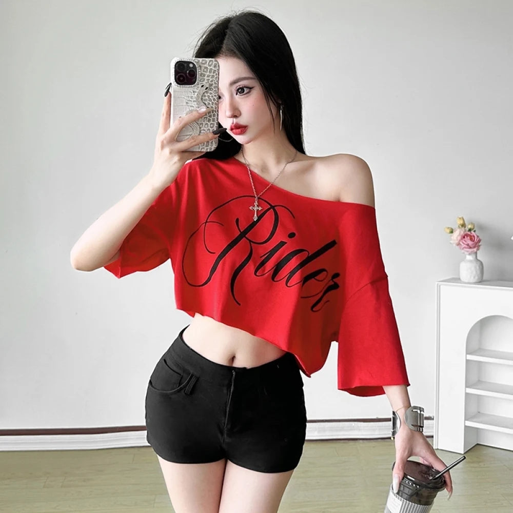 Red oversized crop top with skew off-shoulder collar, short sleeves, black "Rider" letter print, and irregular hem.