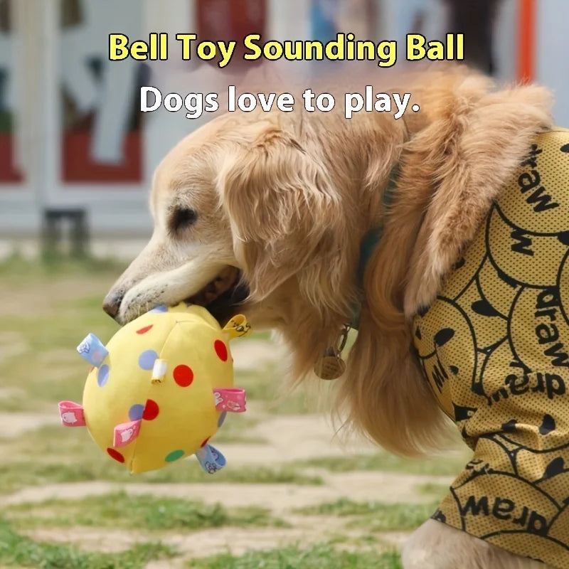 Golden Retriever holding a yellow, polka-dot fleece ball toy with colourful fabric tabs in its mouth.