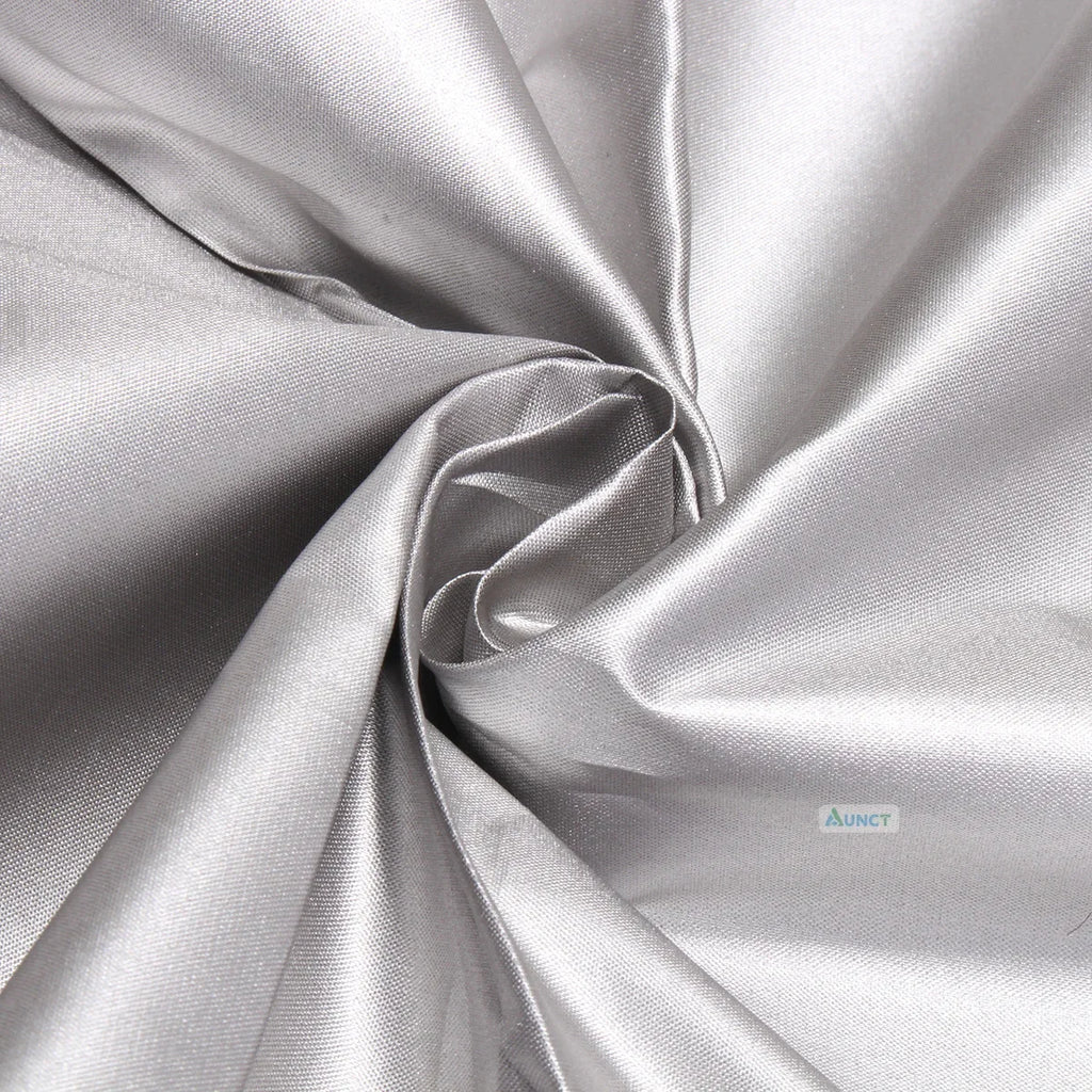 Close-up of a tightly woven, reflective silver fabric, gathered in a swirl.