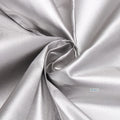 Close-up of a tightly woven, reflective silver fabric, gathered in a swirl.