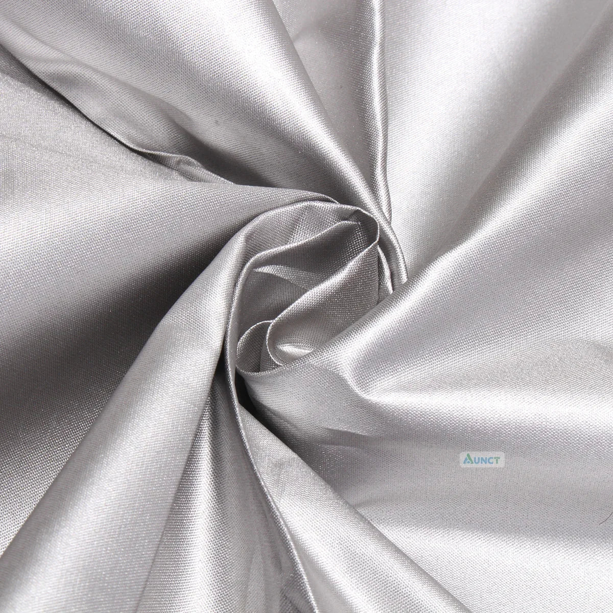 Close-up of a tightly woven, reflective silver fabric, gathered in a swirl.