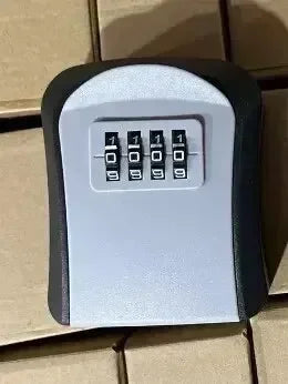Grey and black metal wall-mounted key lock box with a four-digit combination dial.