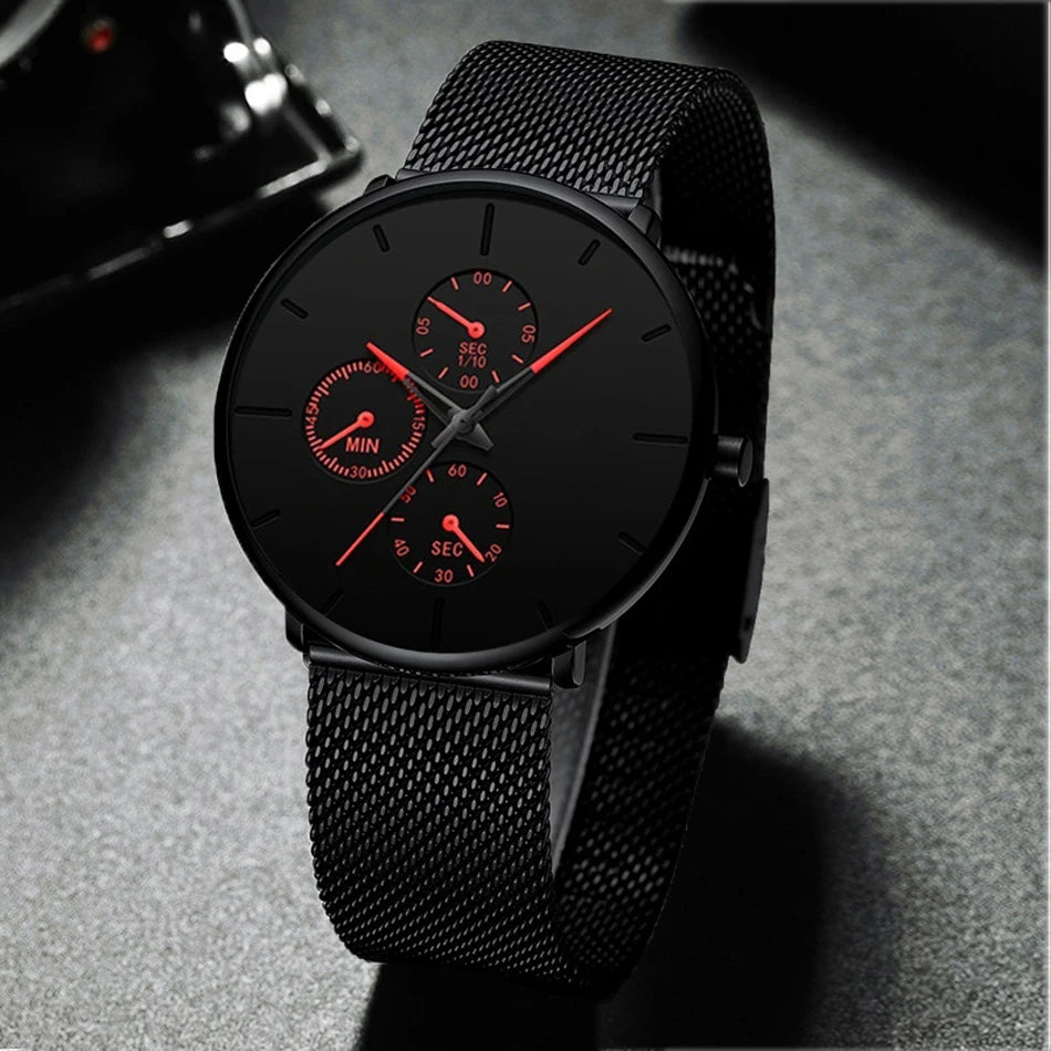 Ultra-thin men's watch with a matte black mesh strap, black dial, and striking red hands and sub-dial markers.