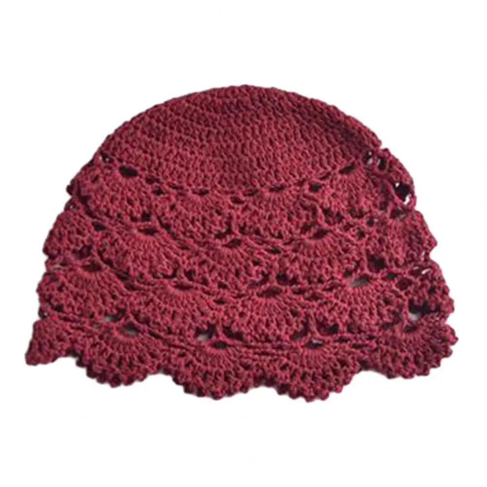 A deep red, hollow-stitch crochet beanie with a delicate scalloped edge.