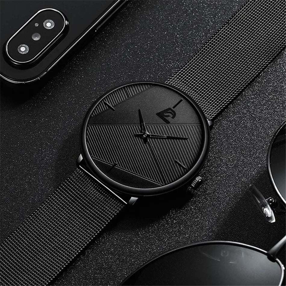 Ultra-thin men's minimalist wristwatch in matte black with a textured dial and sleek stainless steel mesh strap.