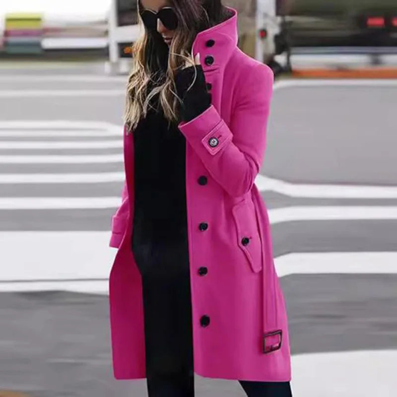 A vibrant hot pink knee-length wool coat with a high collar, black buttons, and belted cuffs.
