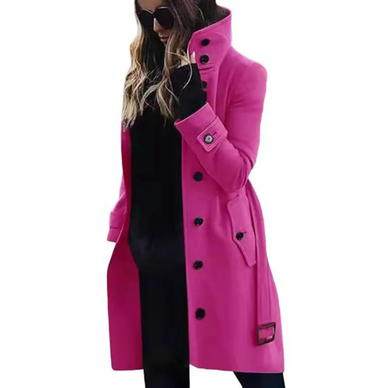 A woman wearing a vibrant, fuchsia-pink, single-breasted wool-blend coat with a high collar, buttons, and side pockets.