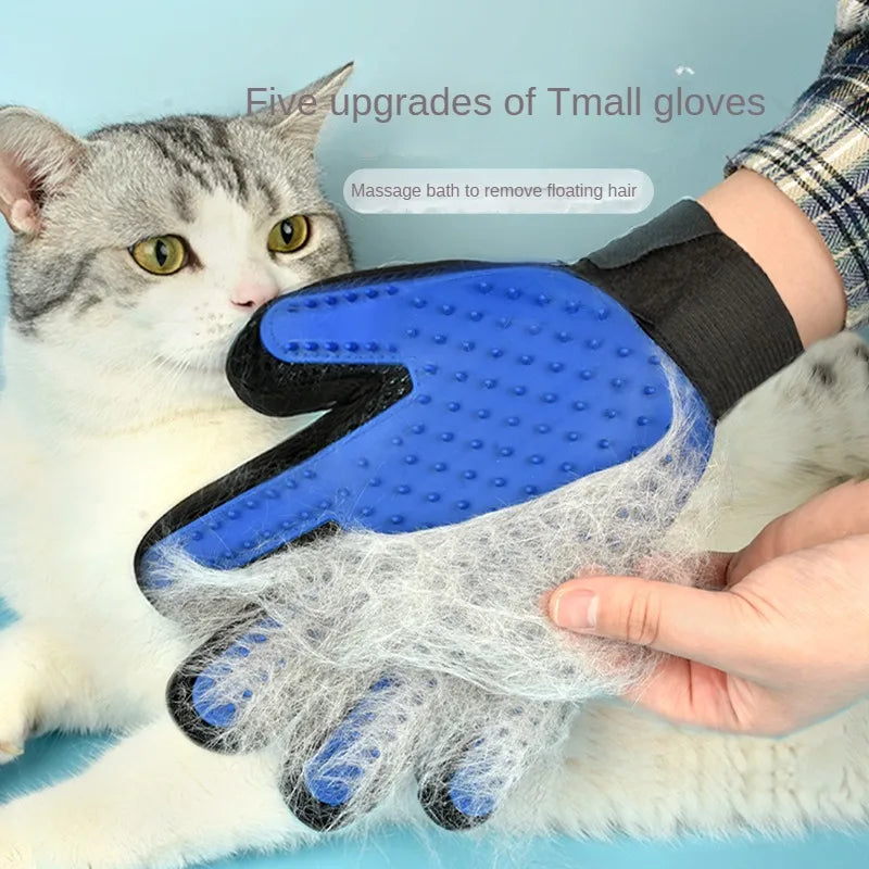 Blue silicone pet grooming glove covered in loose white cat fur, worn on a hand petting a tabby cat.