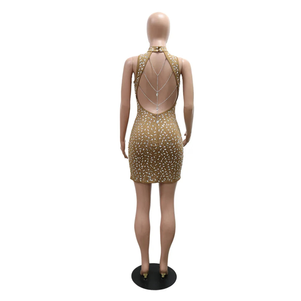 Gold bodycon sleeveless mini dress with rhinestones and backless chain details, shown from behind.