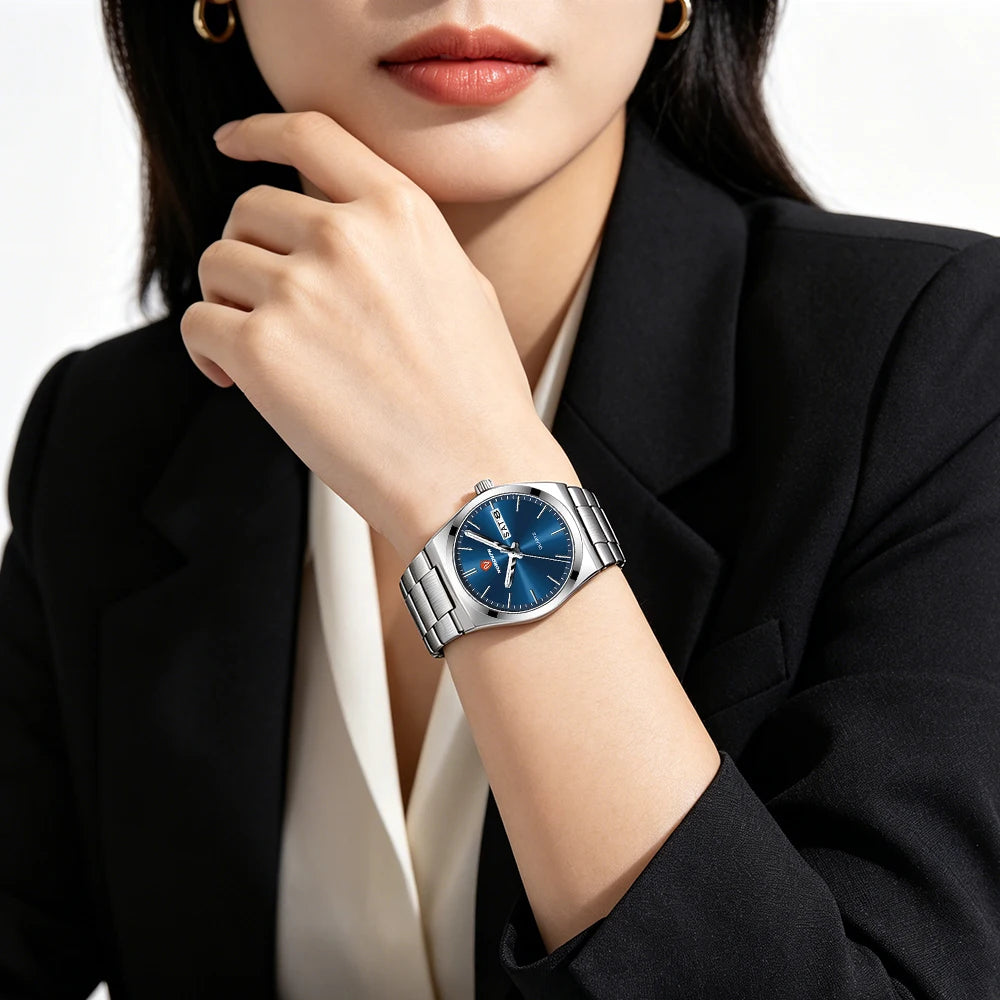 Women’s elegant silver-tone quartz watch with a sleek blue dial and day-date display, worn on a stainless steel strap.