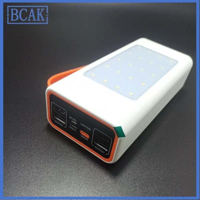 White and orange portable power bank with multiple output ports, built-in LED light panel, and side carry strap.