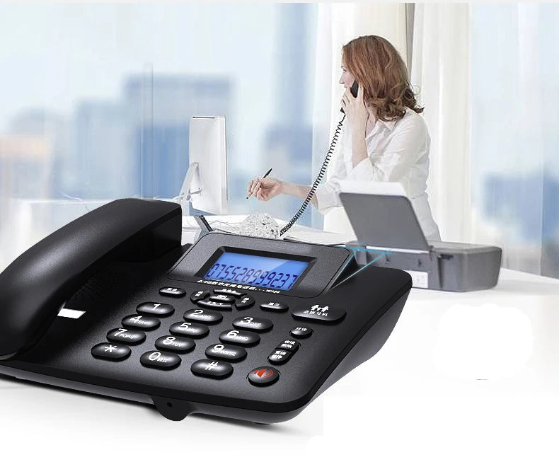 Black corded office telephone with large keypad, illuminated LCD display, and caller ID on a white desk.
