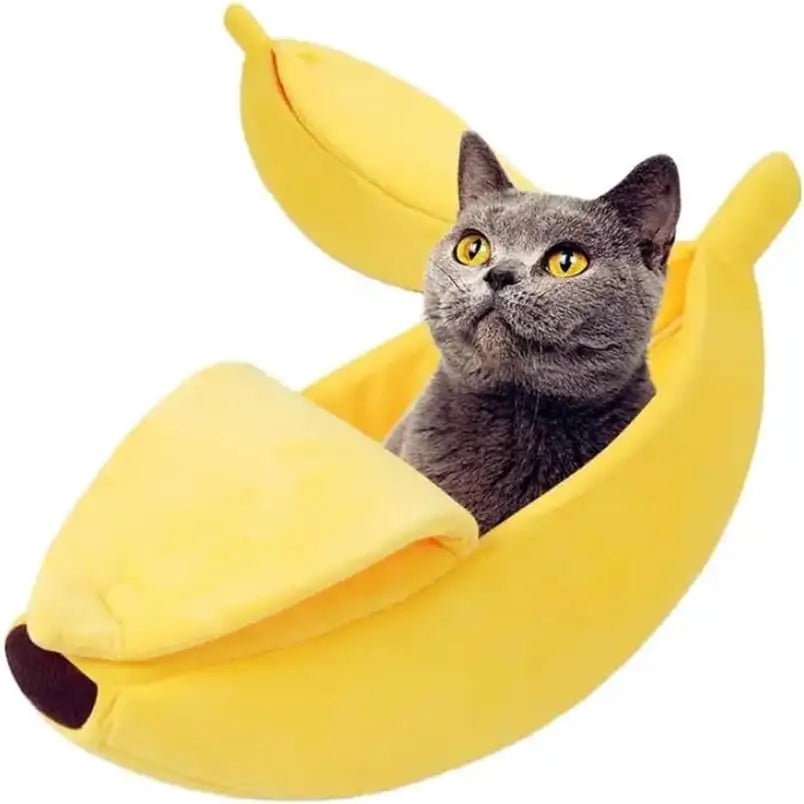 Soft yellow banana-shaped pet bed with peel-like flaps, holding a grey cat with yellow eyes.