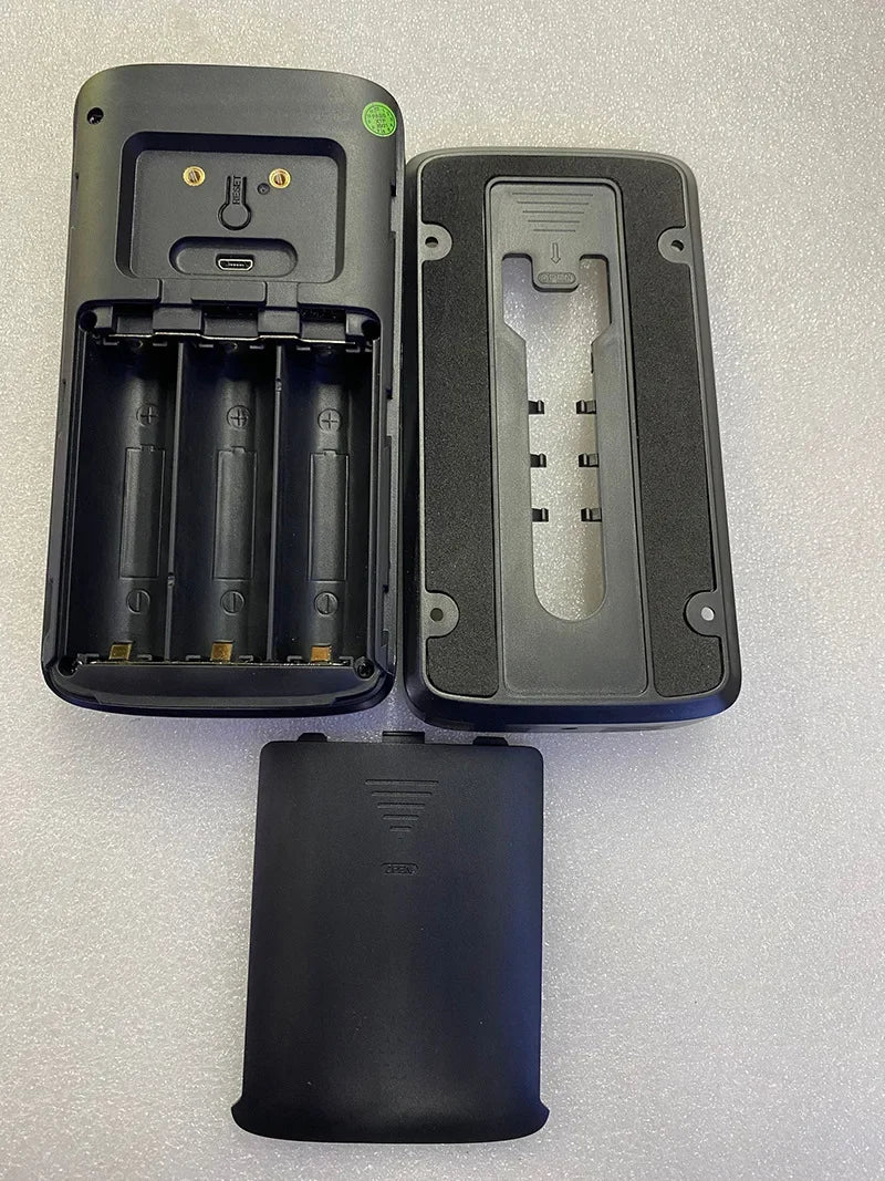 Black smart video doorbell components including the main unit with battery slots, mounting bracket, and battery cover.