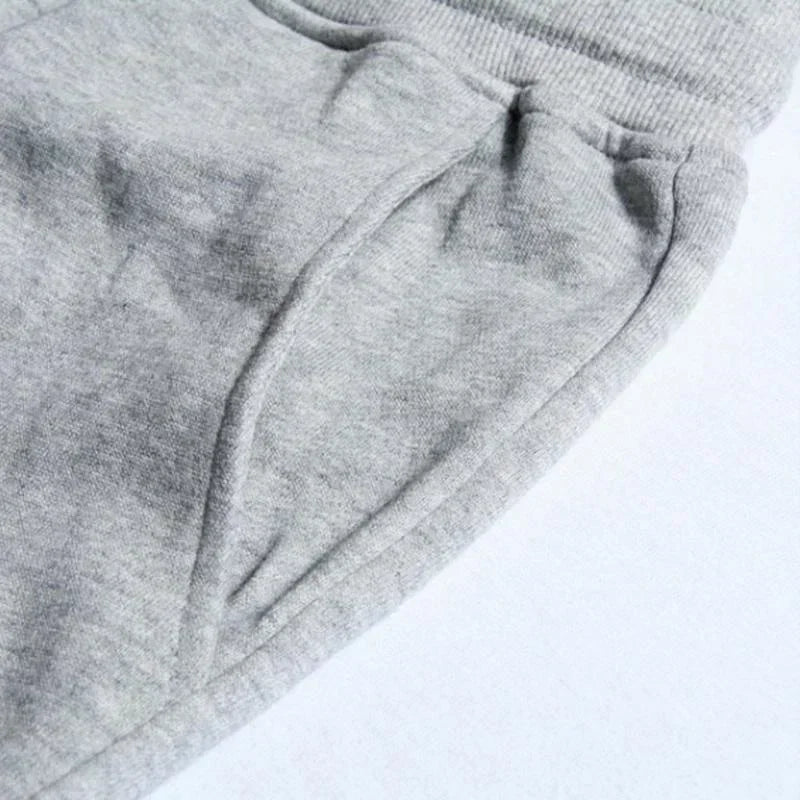 Close-up of soft grey jersey joggers with an elasticated waistband and side pocket detail.