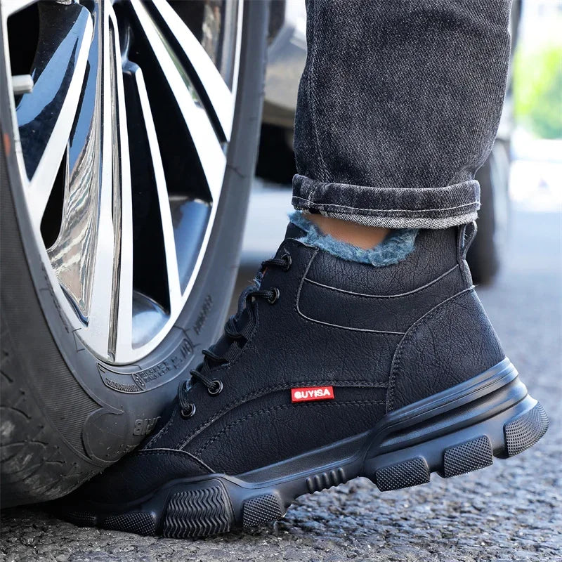 Black leather safety work boot with plush lining, chunky lug sole, lace-up front, and steel toe under car tire.