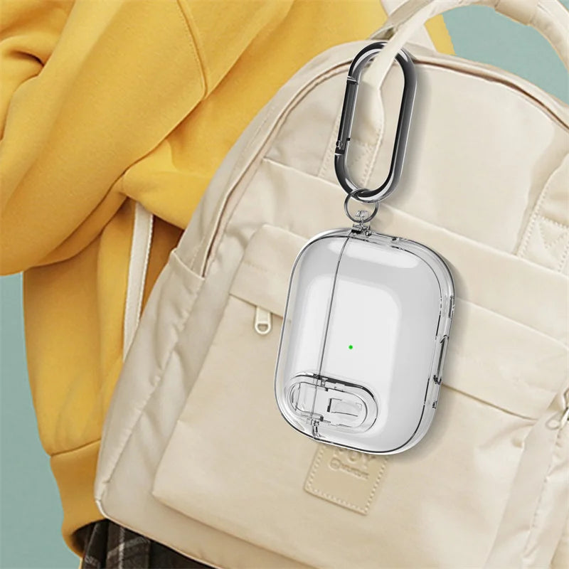 Clear protective AirPods case with metal carabiner clip, hanging from a beige backpack.