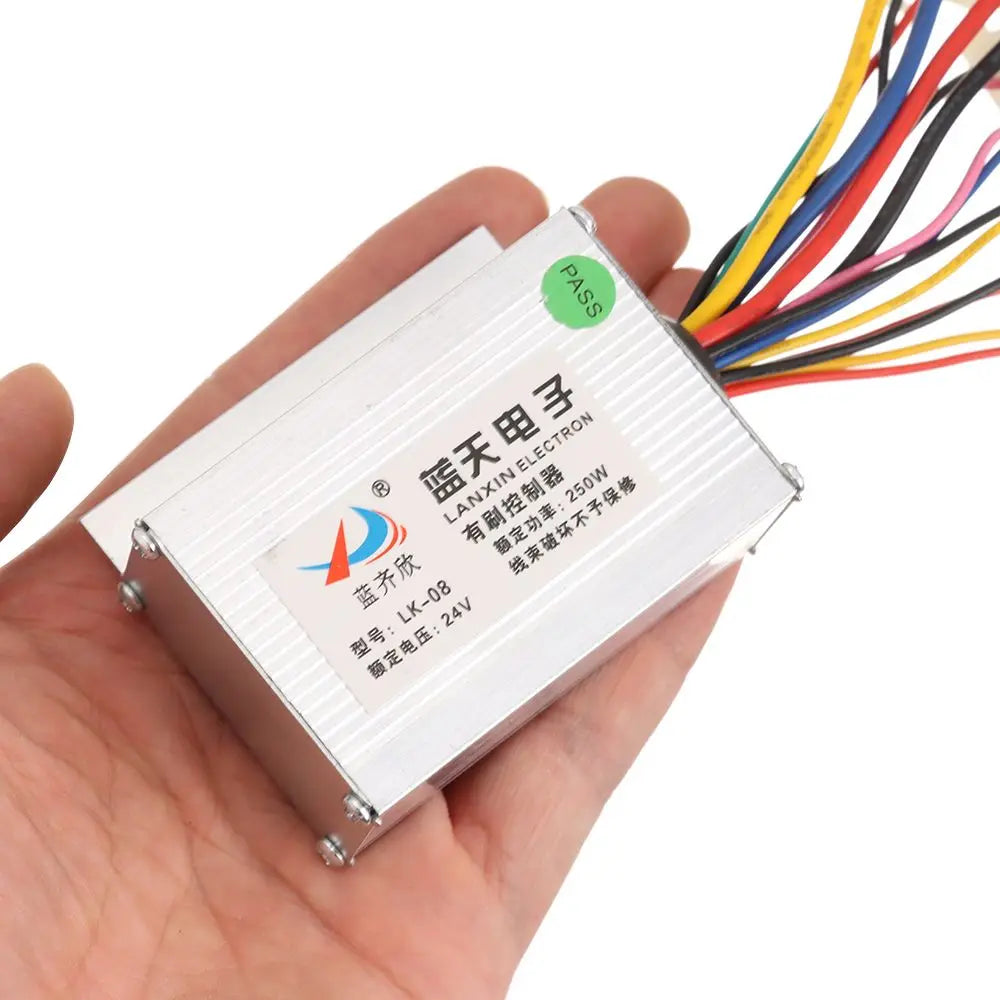 Silver rectangular e-bike brushed motor controller with a label and multicolored wires held in hand.