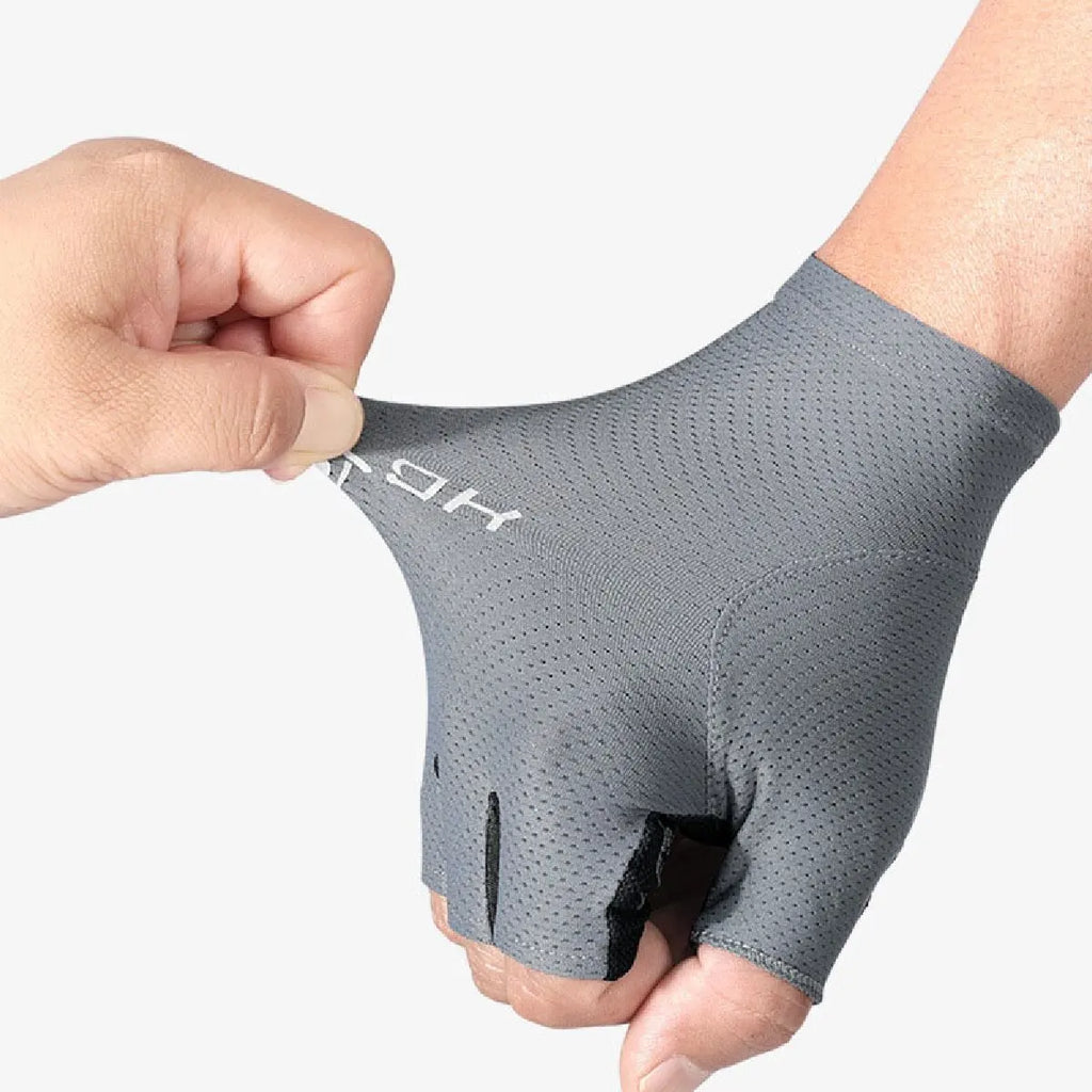 A hand pulling on a stretchy, grey fingerless cycling glove with breathable mesh fabric and white branding.