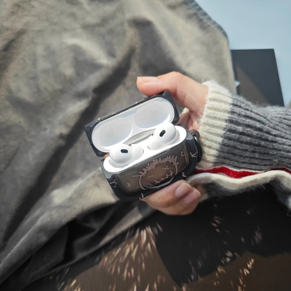 Black graphic silicone AirPods Pro case with face design, held in a hand.