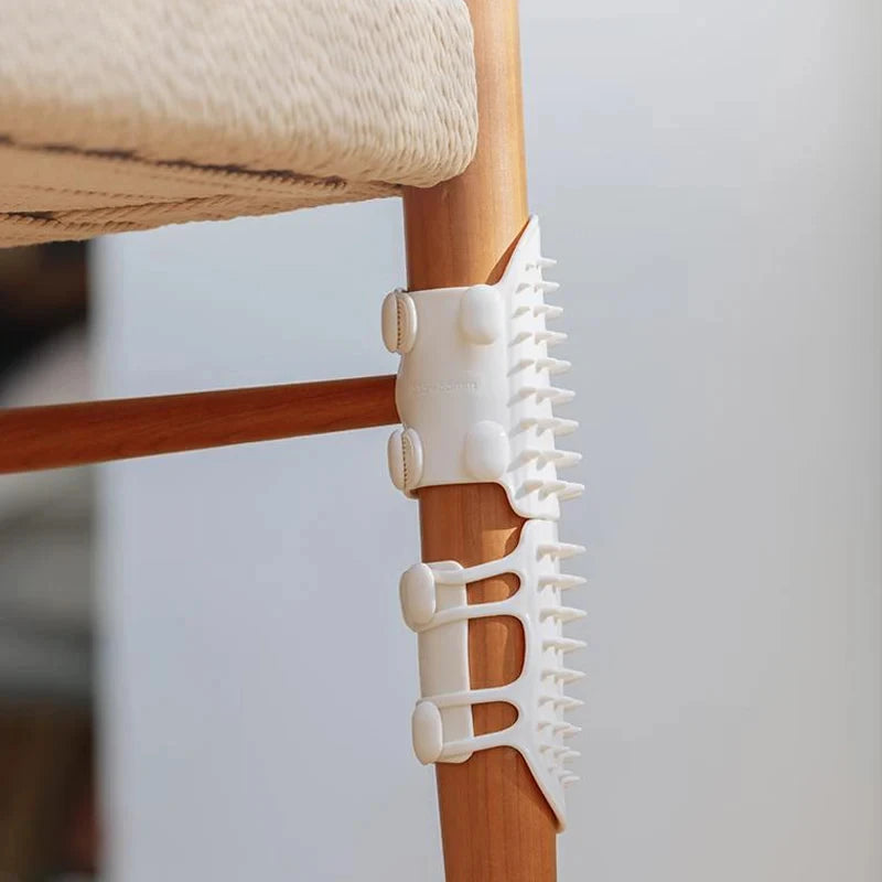 White plastic anti-scratch spikes attached to the leg of a wooden chair.