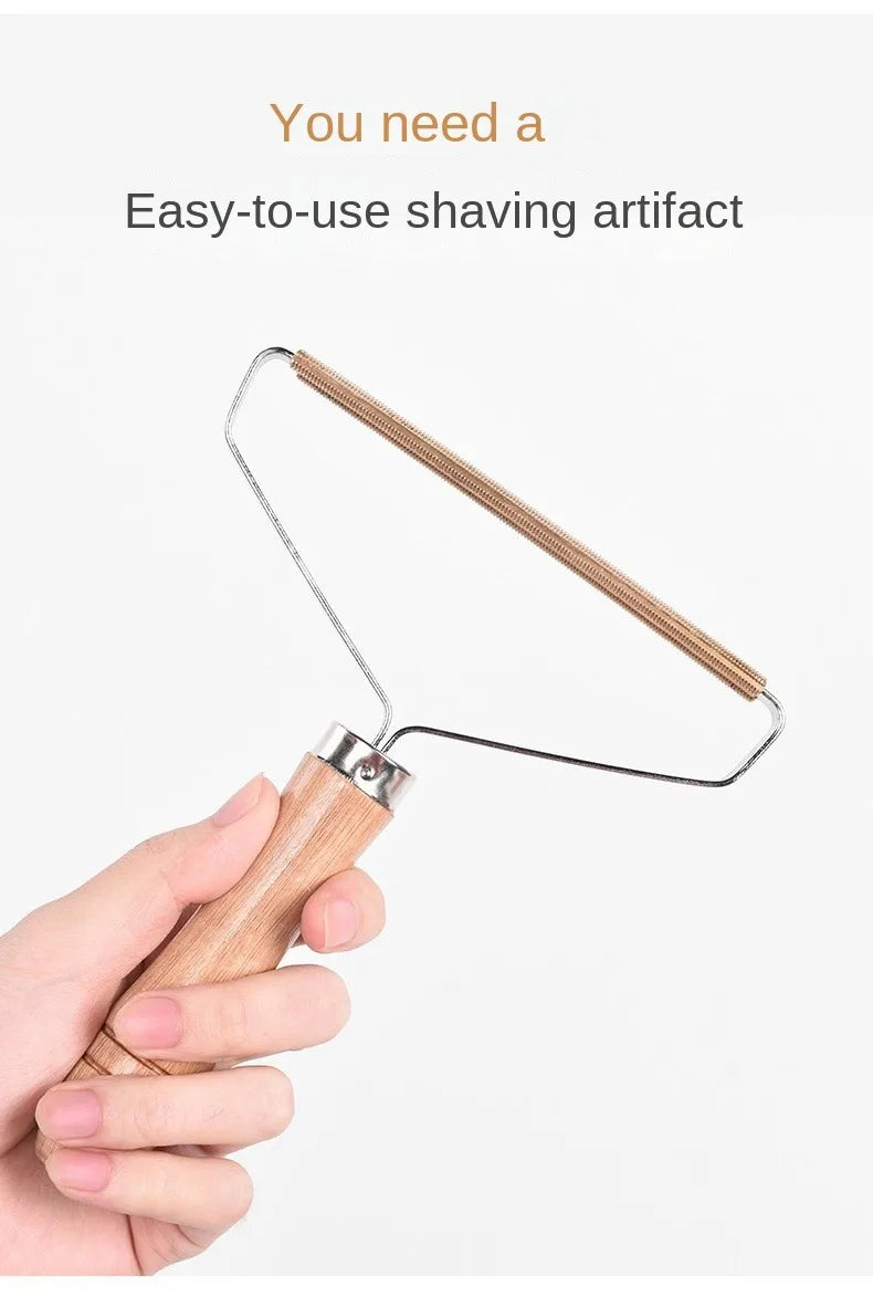 Hand holding a wooden-handled fabric lint remover with a metal blade head against a white background.
