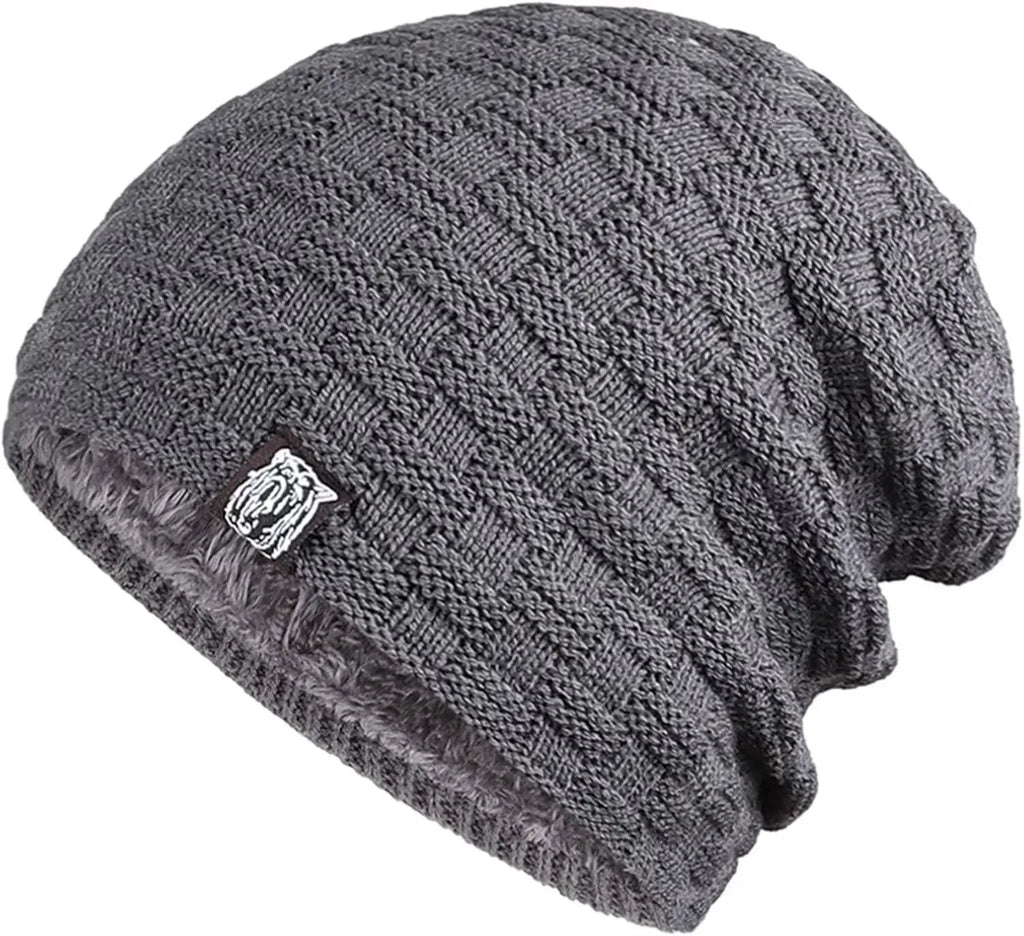 Grey, chunky-knit unisex beanie hat with a warm, plush faux-fur lining and a small rectangular tab detail.