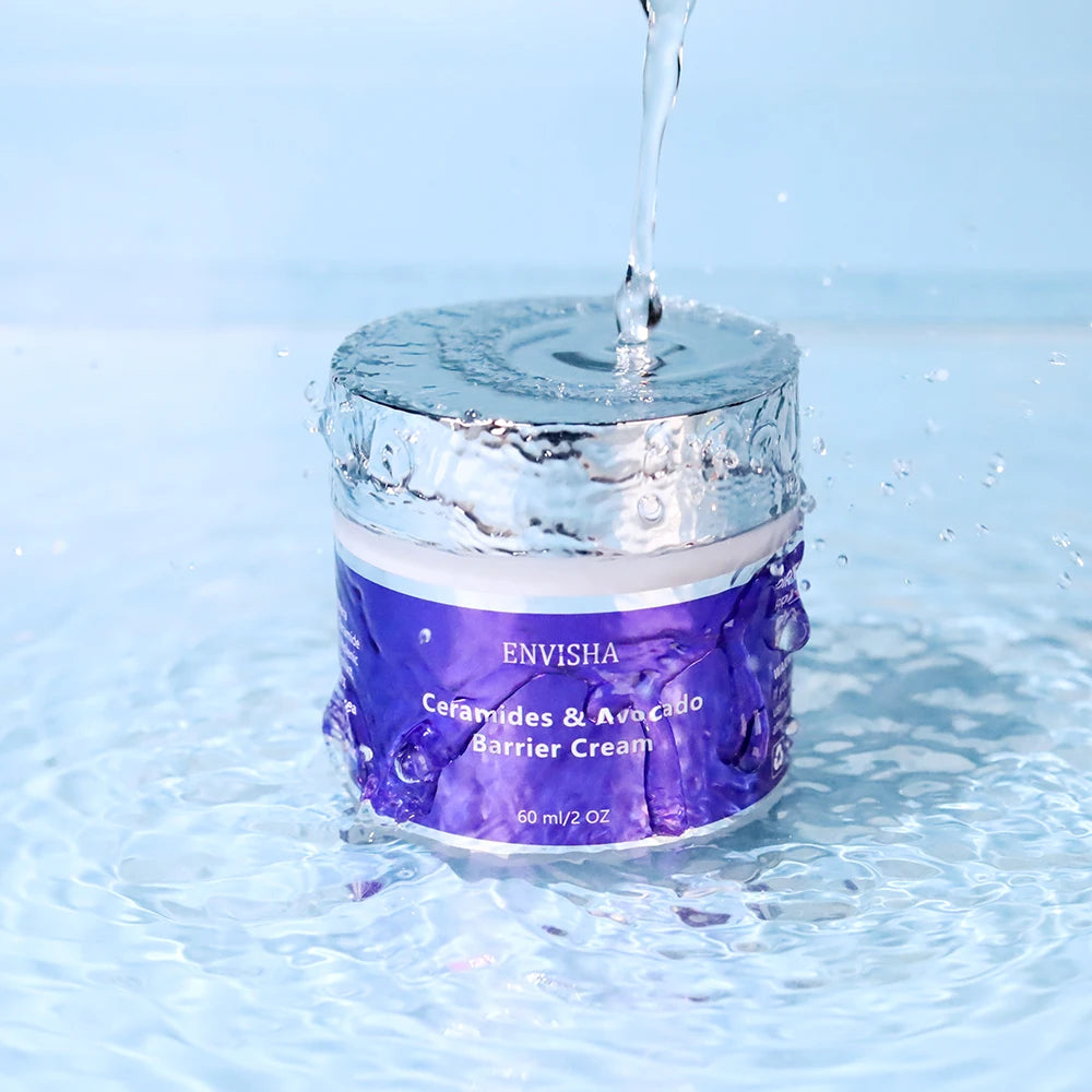 Purple jar of Ceramide and Avocado barrier cream with a silver lid, splashing in water against a light blue background.