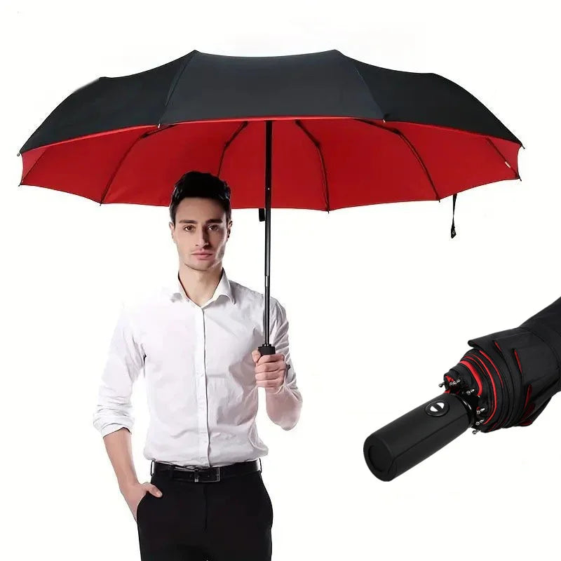 Man holding a large, double-layer folding umbrella with a black exterior, red interior, and automatic handle.