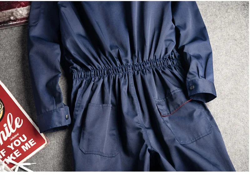 Navy blue long-sleeved cotton coveralls with a cinched elastic waist and two front patch pockets.