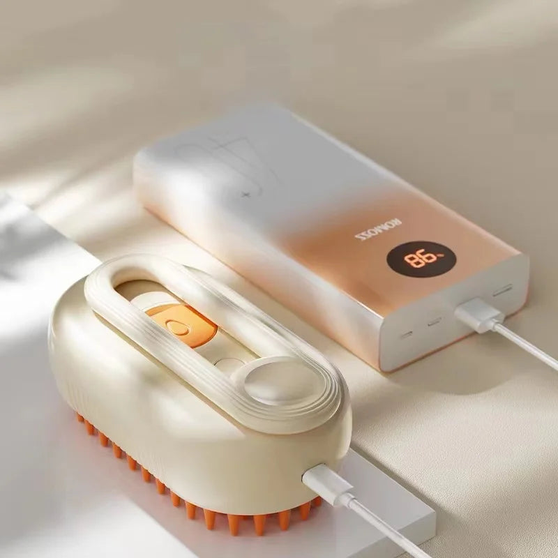 A cream-coloured electric massage brush with orange bristles, plugged into a white Romoss digital power bank.