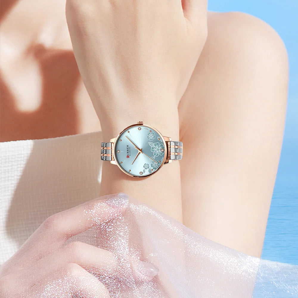 CURREN women's quartz watch with a round light blue floral dial and silver-and-rose-gold stainless steel band.