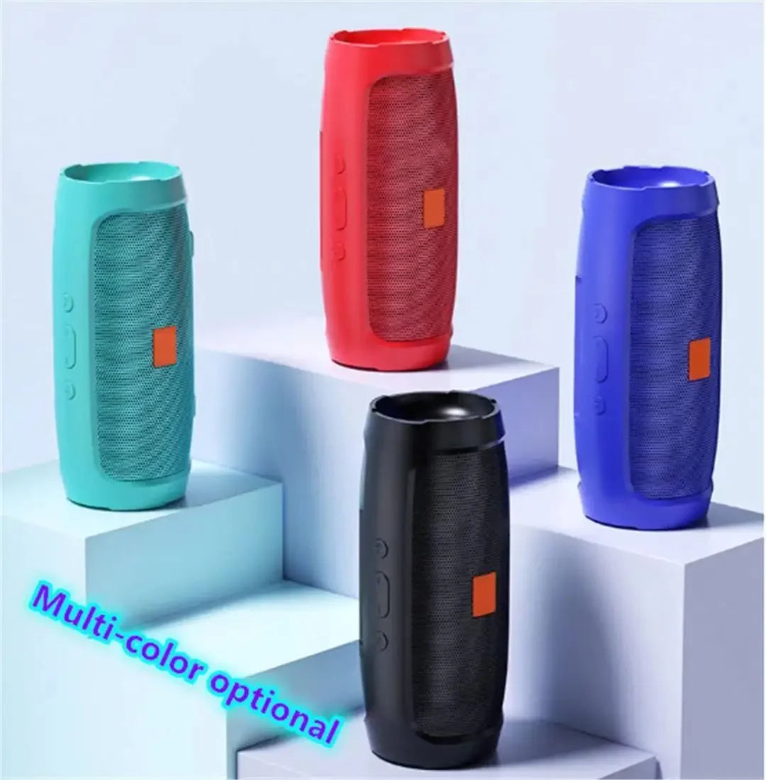 Four cylindrical portable wireless speakers in red, blue, black, and turquoise displayed on tiered white platforms.