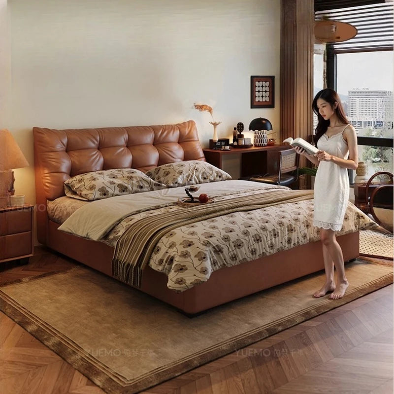 Modern Nordic double bed with a tan button-tufted leather headboard and a low-profile frame in a warm, cosy bedroom.