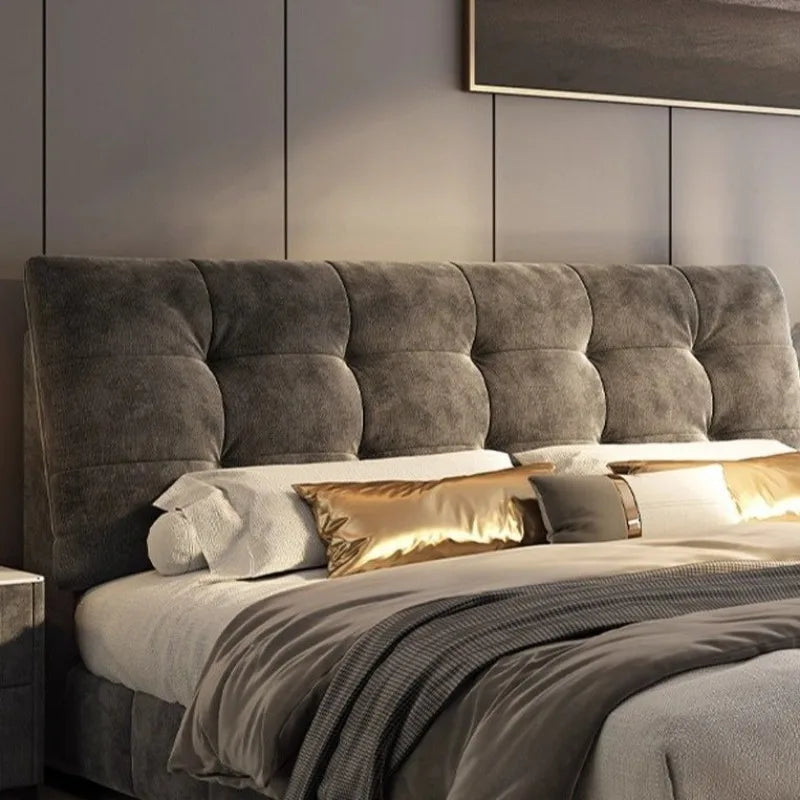 Luxury grey bed frame with a minimalist, deep-tufted headboard, styled with soft white and gold cushions.