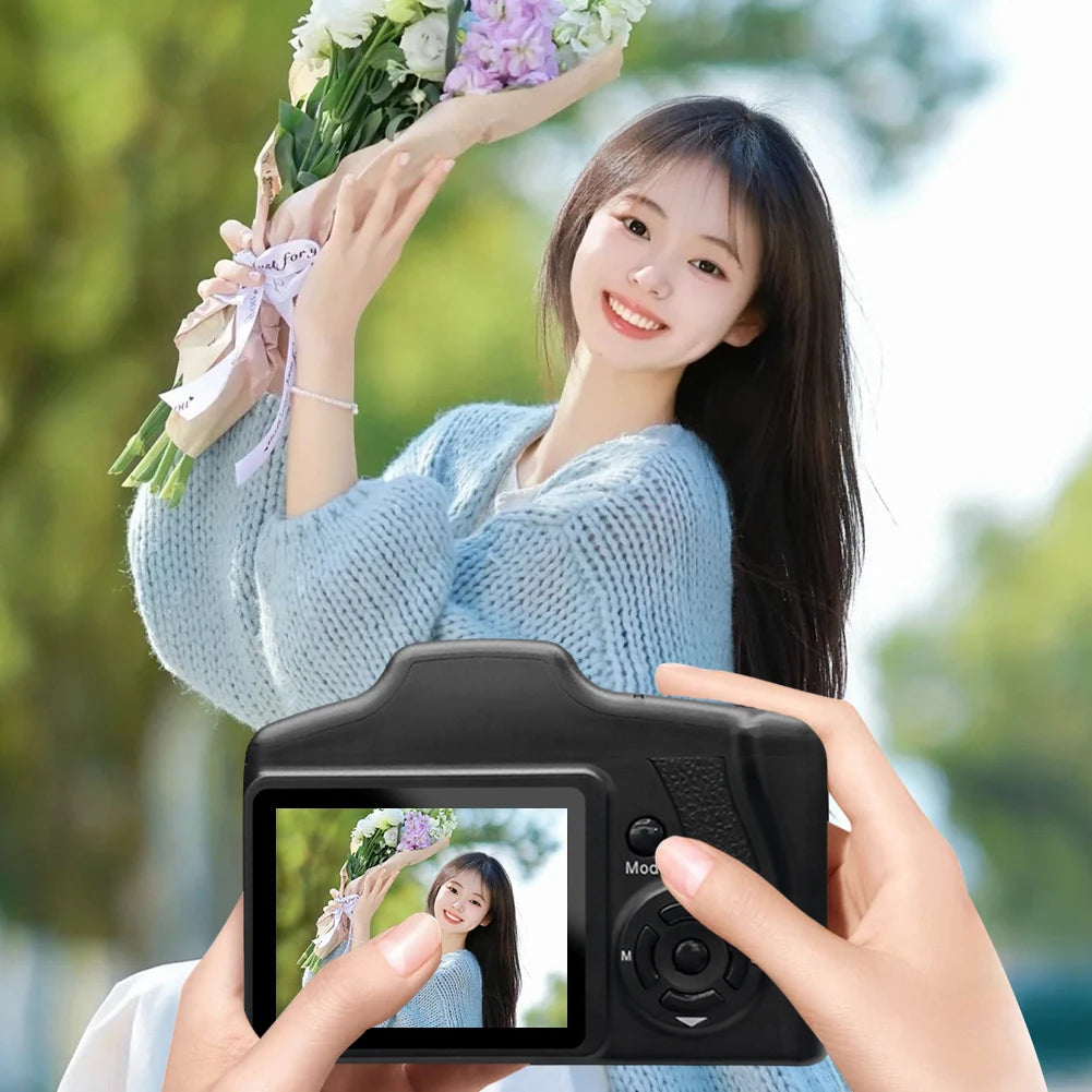 Black plastic digital camera with a rear LCD screen, side-mounted buttons, and directional pad controls.