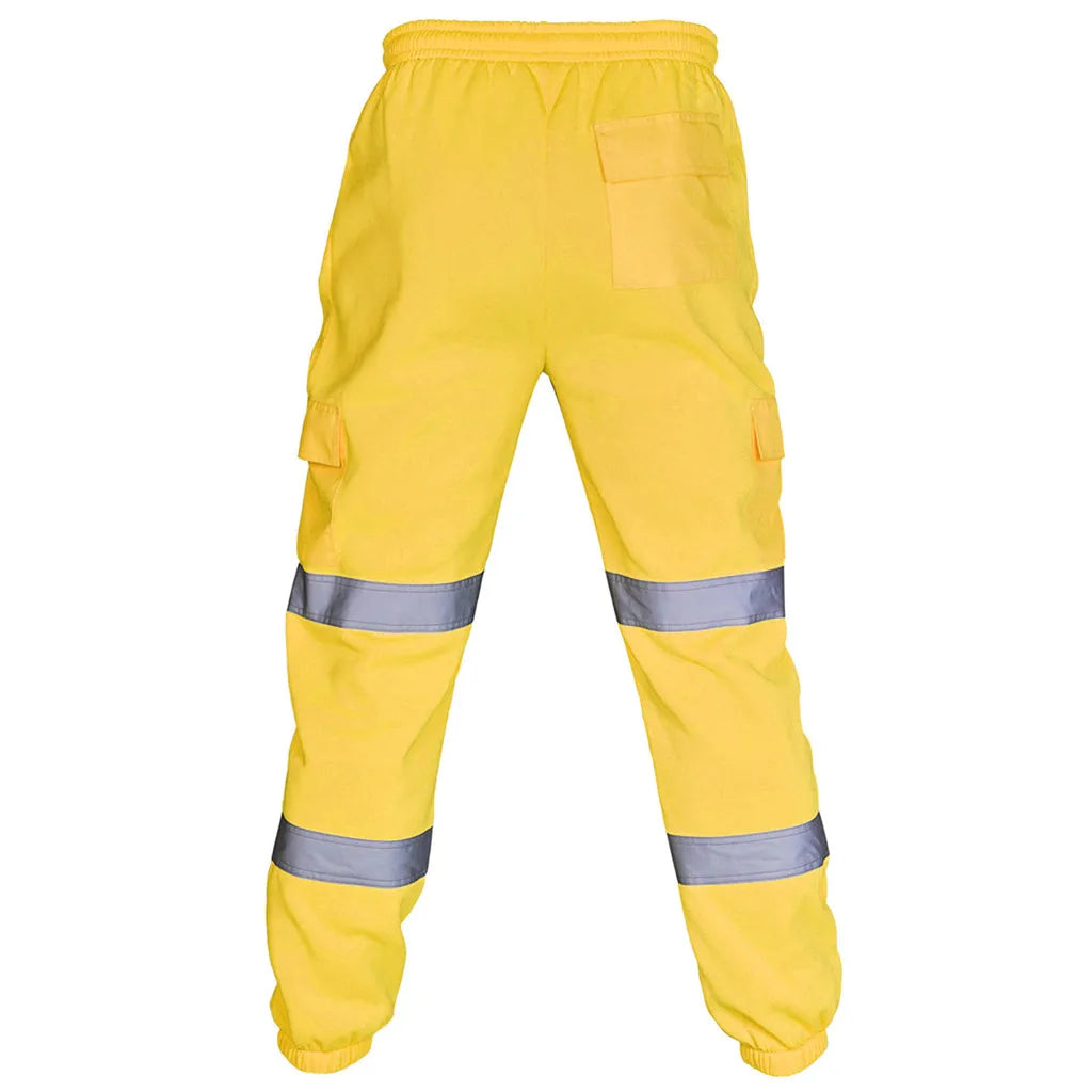 Back view of high-visibility yellow work trousers with elasticated waist, side cargo pockets, and reflective leg strips.