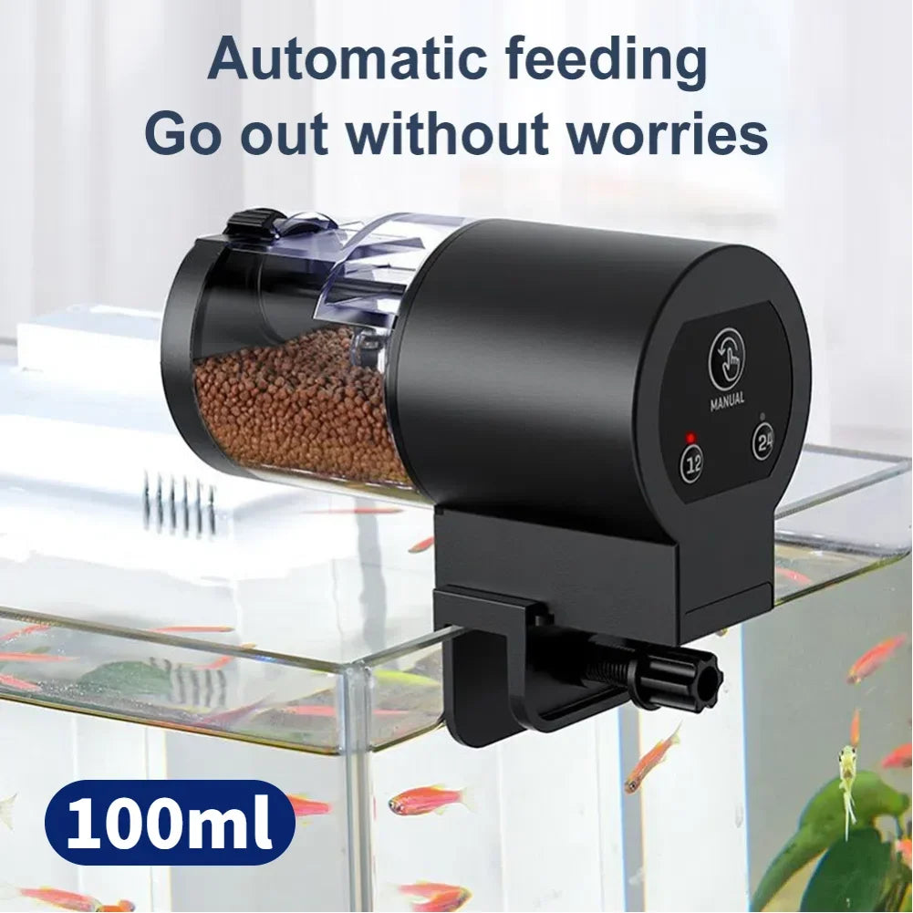 Black automatic fish feeder with a clear 100ml food container, mounted on the side of a glass aquarium.