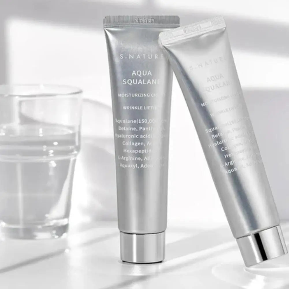 Two silver squeeze tubes of Aqua Squalane moisturizing cream, featuring wrinkle-lifting ingredients on a white surface.