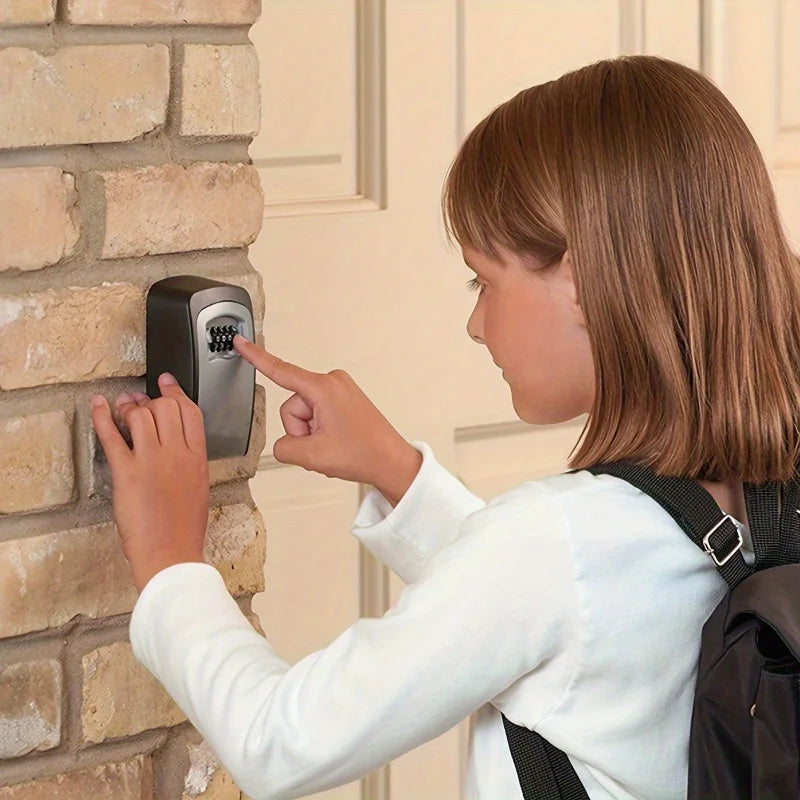 A girl using a black metal wall-mounted combination lock box attached to a brick wall.
