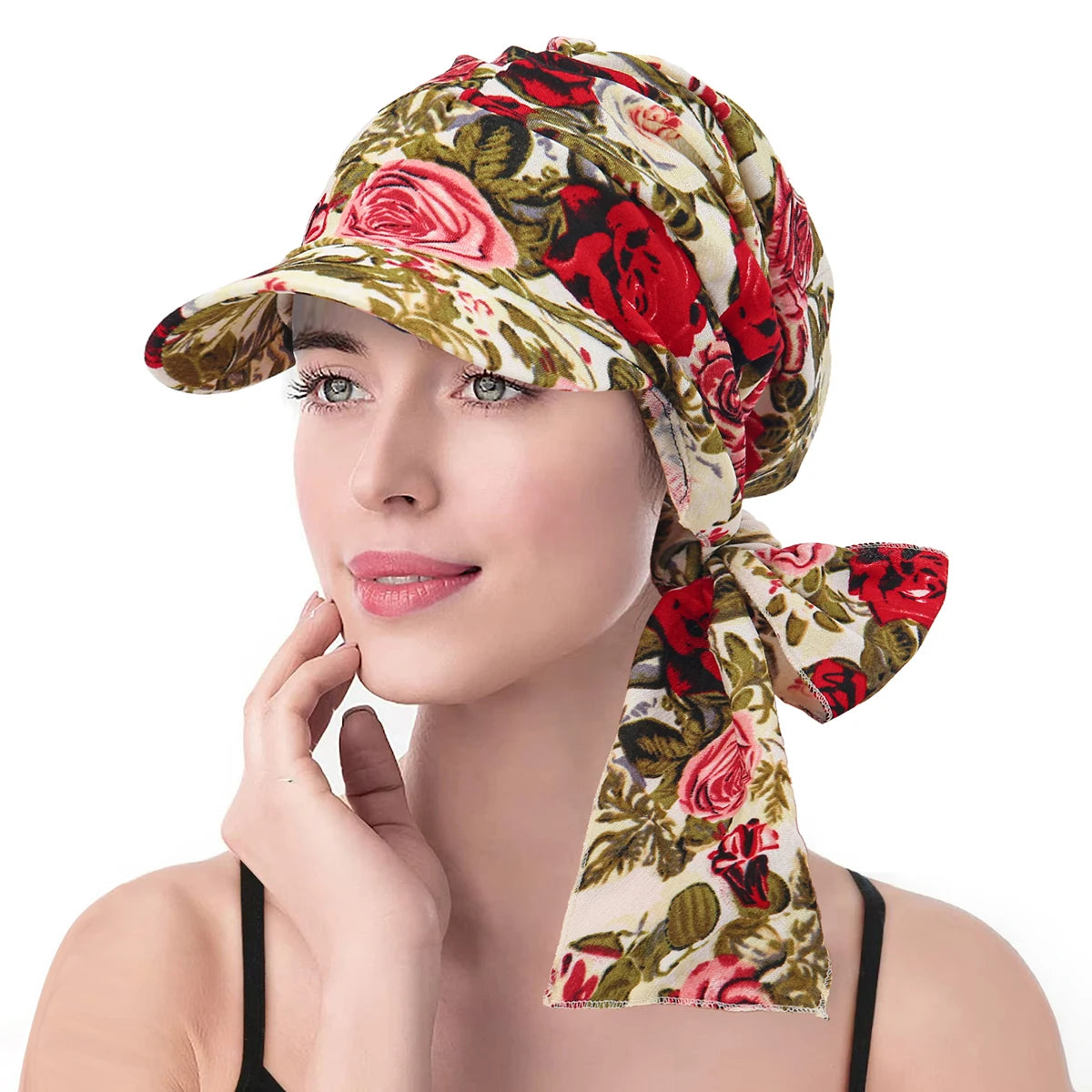 A vintage-style floral turban hat with a brim and side tie, featuring a cream base with red and pink rose patterns.