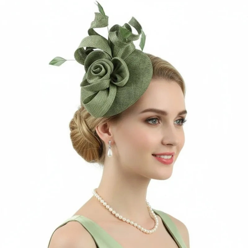 Sage green fascinator hat featuring a structured fabric rose and delicate leaf accents, worn as a side headpiece.