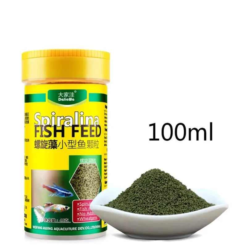 A 100ml yellow tub of spirulina fish food granules, shown with a small pile of green granular fish feed.