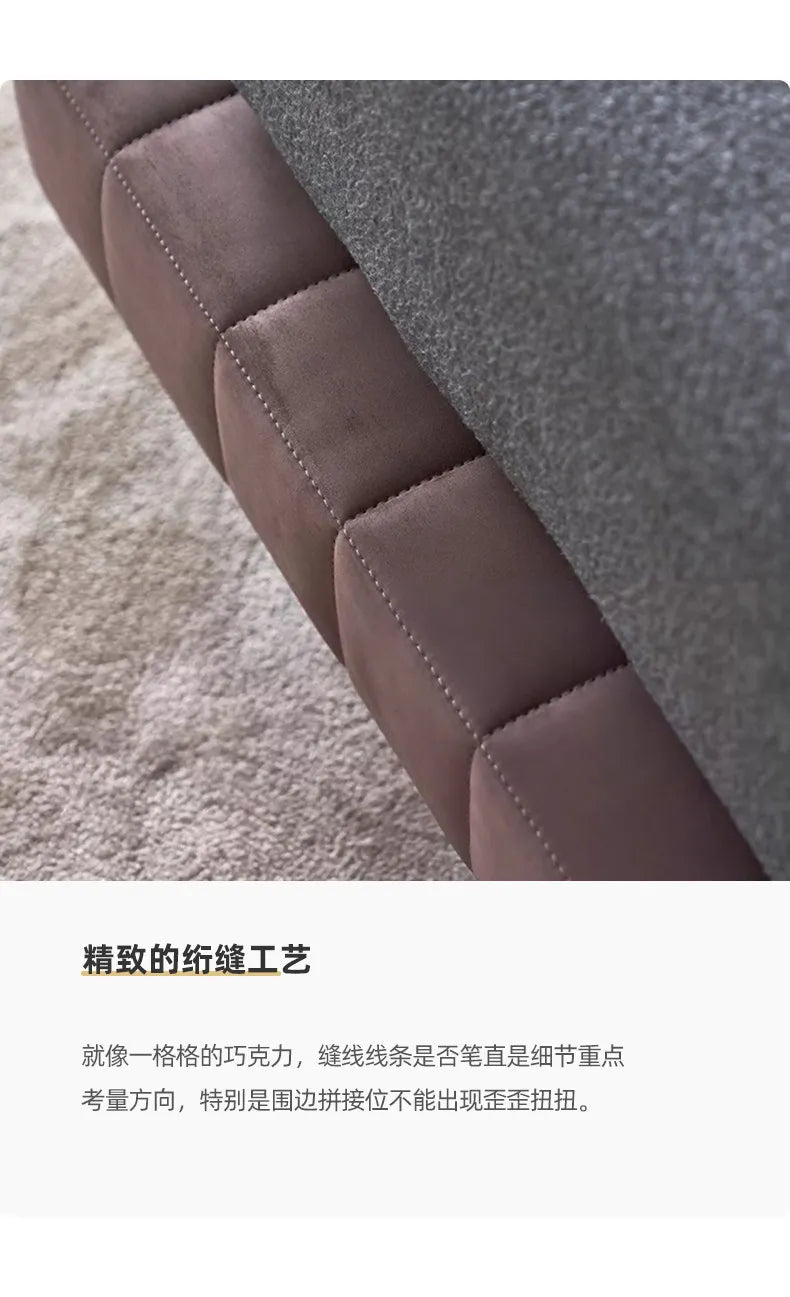 Close-up of a modern, taupe-brown upholstered bed frame featuring neat, square-stitched detailing.