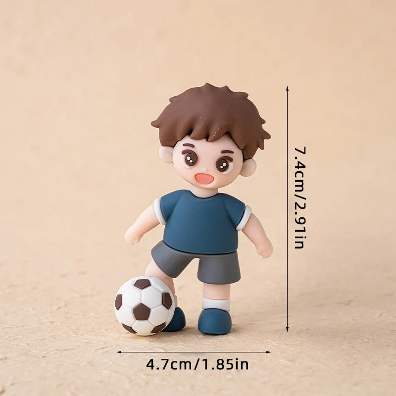 Cute boy figurine with brown hair, blue T-shirt, and grey shorts, standing with a football. Height 7.4cm, width 4.7cm.