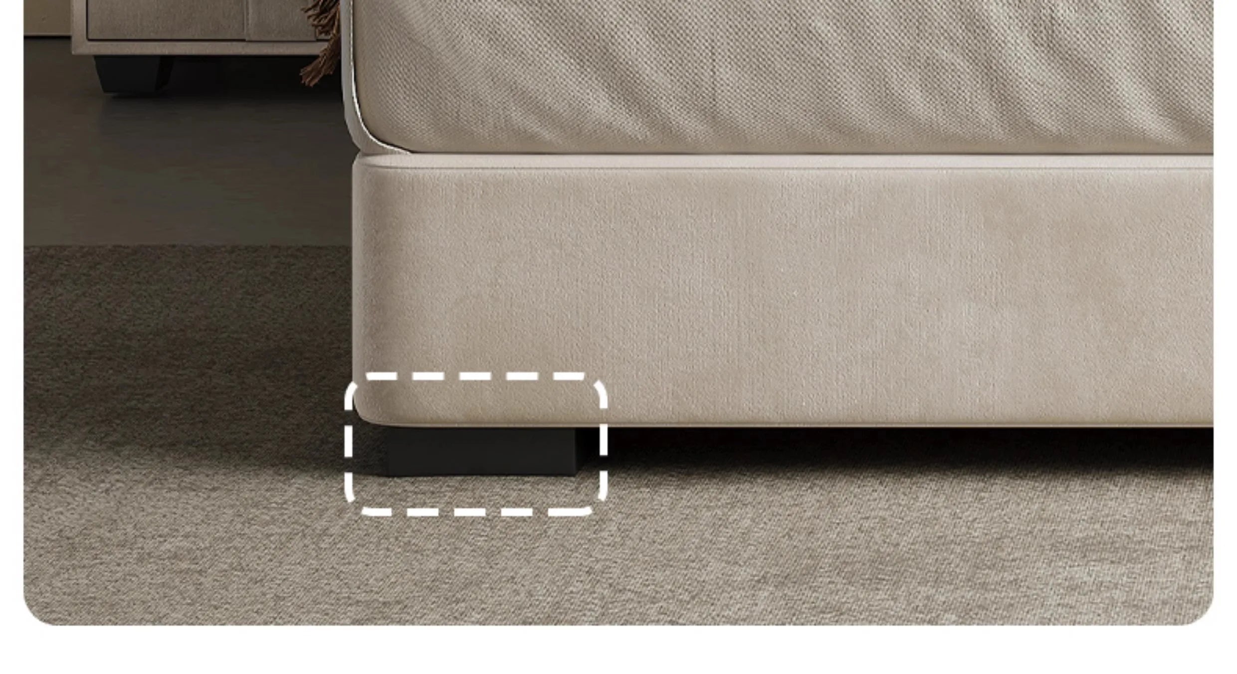 Close-up of a modern beige upholstered storage bed with a low-profile dark block foot on a carpeted floor.