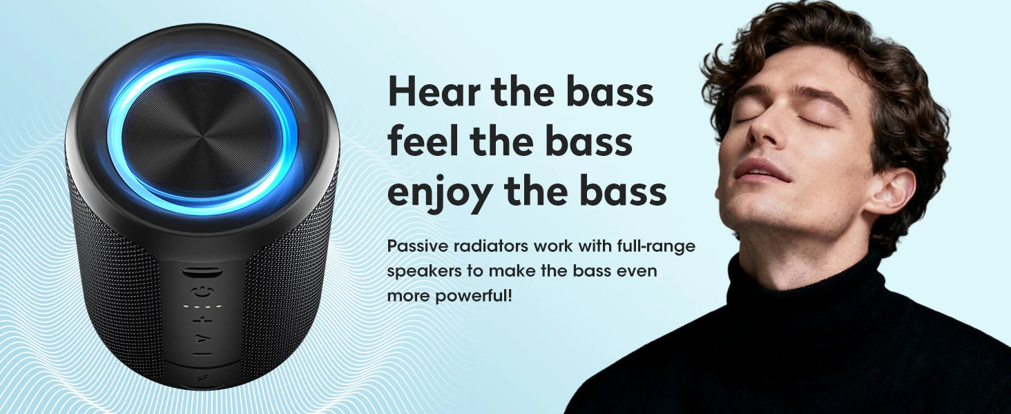 Portable black cylindrical Bluetooth speaker with a glowing blue light ring, beside a man listening to music.
