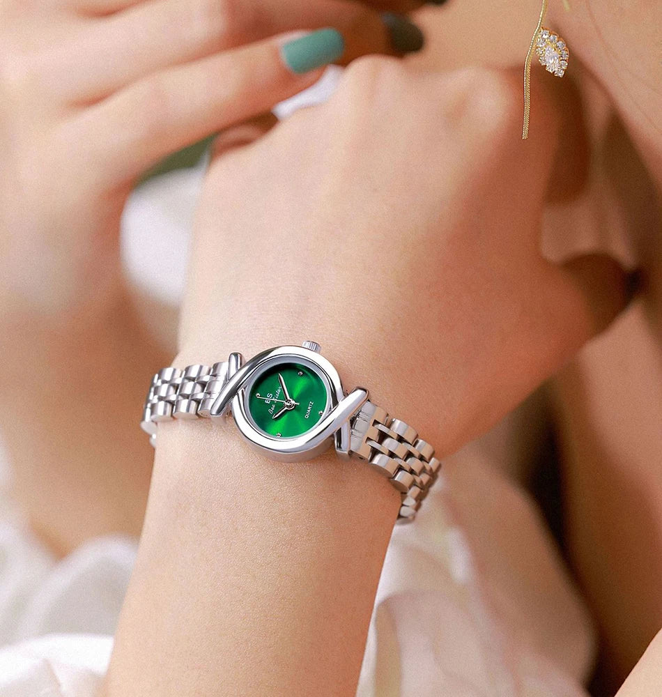 Elegant women's silver-tone stainless steel quartz watch with a round green dial and crossover strap detailing.