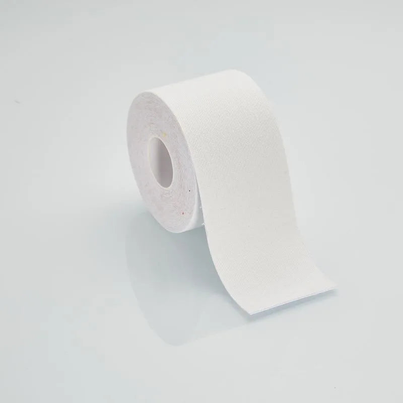 A single roll of white medical or sports kinesiology tape on a plain, light grey background.
